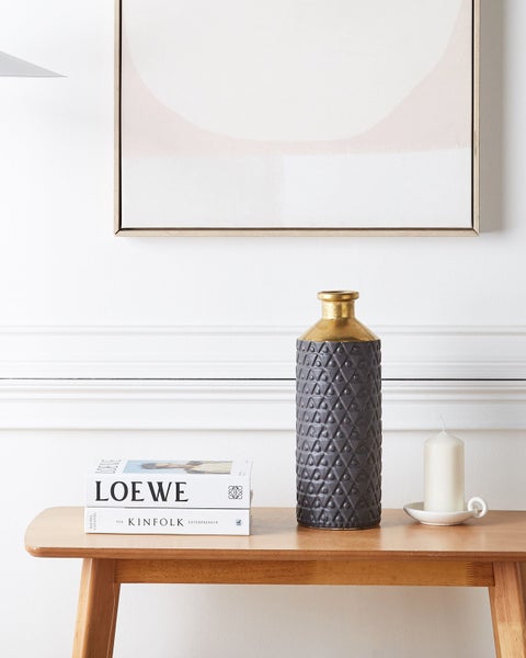 Dekorative Vase mit geometrischem Muster in Händen