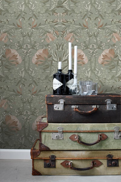 Szene mit Vintage-Tapete mit floralem Muster, gestapelten Koffern, Getränkeflaschen und Kerzen