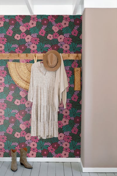 Szene mit floral gemusterter Tapete, Kleiderschrank, Kleid, Hut und Stiefeln