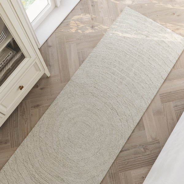 Beige strukturierter Läufer mit konzentrischem Kreismuster.