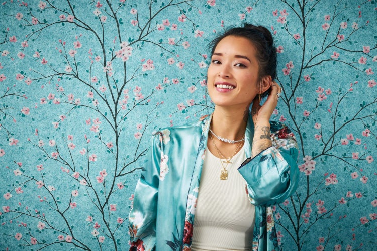 Dekorative Wand mit floralem Muster, gerahmtes Porträt und Zimmerpflanze