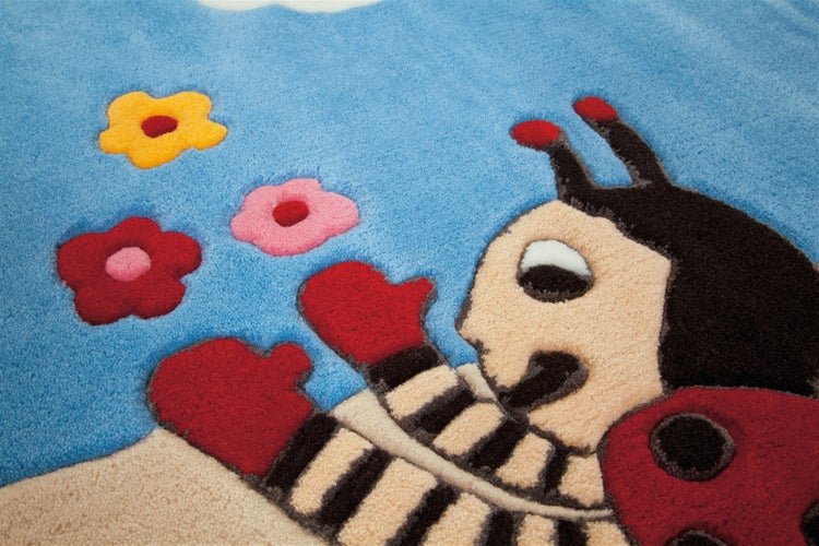 Weicher Kinderteppich aus Textil mit dem Motiv Der kleine Maulwurf und Blumen.