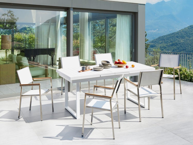 Gartenszene mit weißem Gartentisch und Stühlen auf der Terrasse