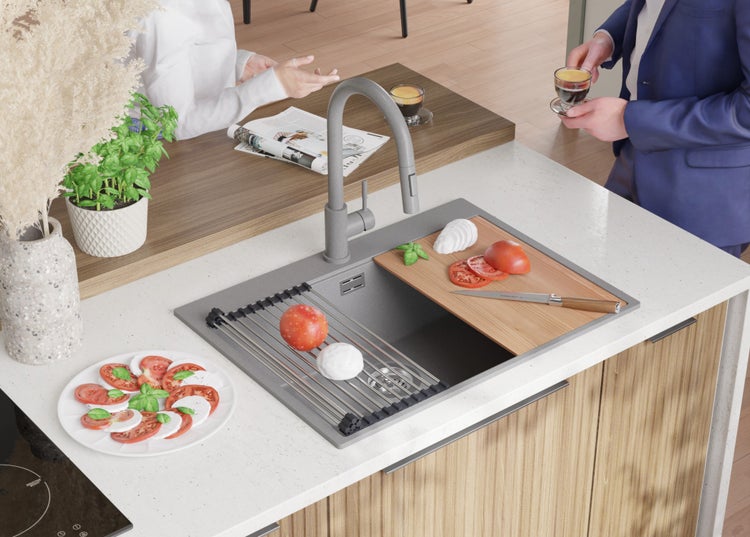 Küchenszene mit Spüle, Armatur, Schneidebrett, Tomaten, Mozzarella und Basilikum