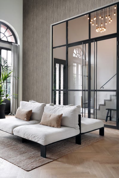 Wohnzimmer mit Sofa, Teppich, Tapete und Glastür