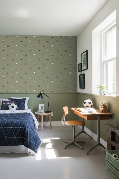 Dekoriertes Jugendzimmer mit Bett, Schreibtisch und Fußballmotiven