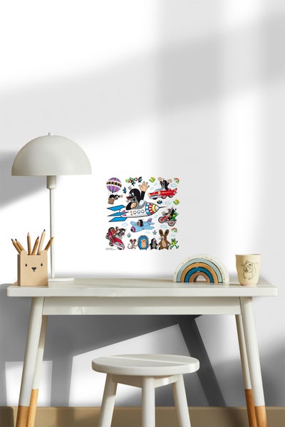 Dekoriertes Kinderzimmer mit einem Wandbild, das den kleinen Maulwurf in verschiedenen Fahrzeugen zeigt, Schreibtisch mit Stifthalter und Lampe