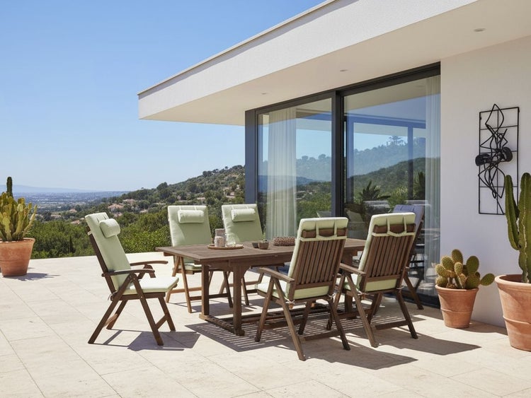 Gartensitzgruppe mit Tisch und Stühlen auf einer Terrasse.