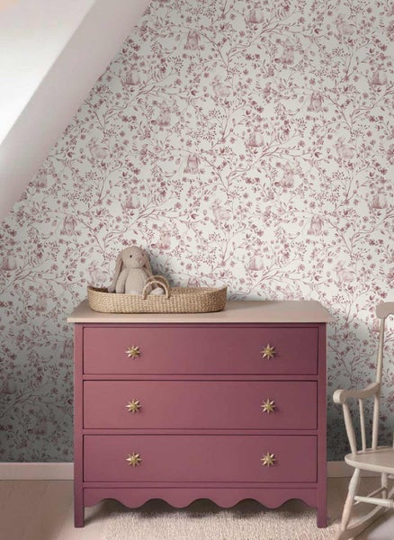 Vliestapete mit Hasen und Blumenmuster in einem Kinderzimmer hinter einer Kommode.