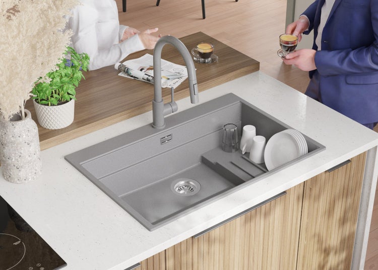 Küchenspüle mit Wasserhahn und Geschirr auf einer Küchentheke