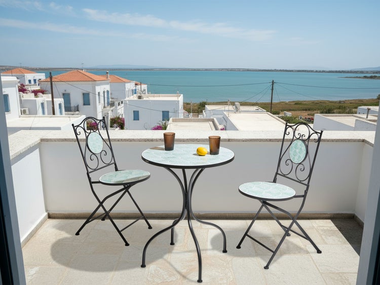 Balkon mit Gartentisch und zwei Gartenstühlen mit Meerblick