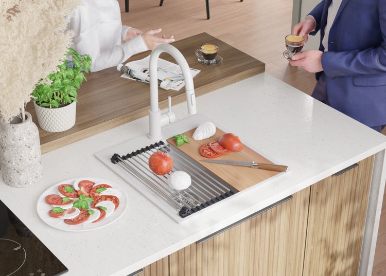 Küchenszene mit Spüle, Armatur, Abtropfgestell, Schneidebrett und Zutaten für Caprese