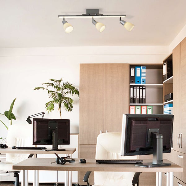 Büro mit Schreibtischen, Computern, Aktenschränken und Deckenleuchte mit drei Strahlern