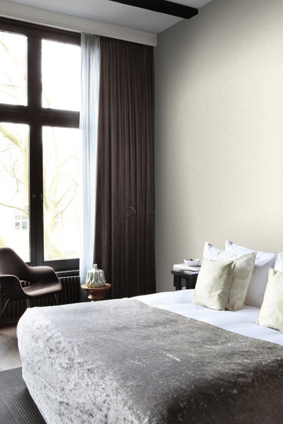 Schlafzimmer mit Bett, Vorhängen und Stuhl