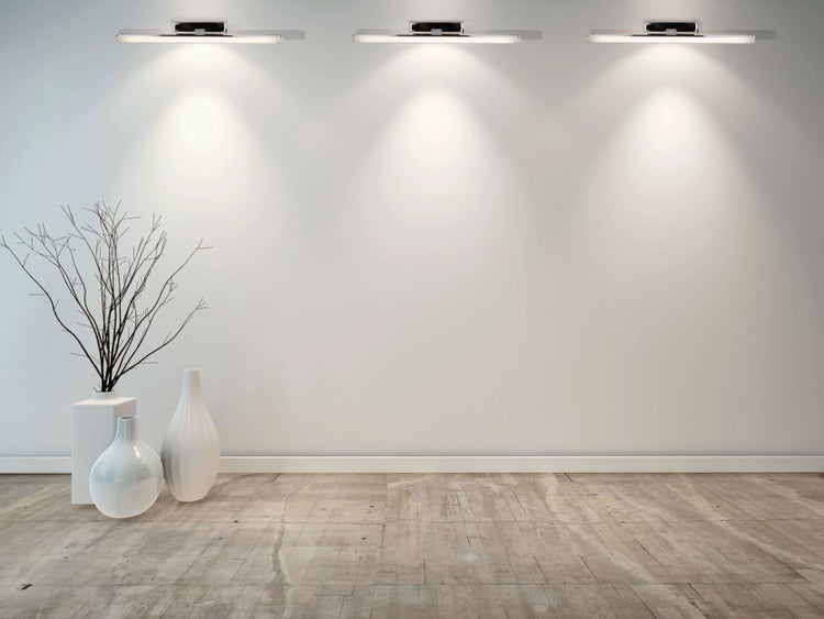 Heller Raum mit drei Wandleuchten, Vasen und Deko-Zweigen