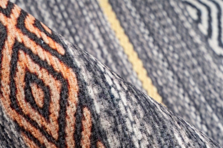 Detailansicht eines gewebten Teppichs mit geometrischem Muster und strukturierter Oberfläche.