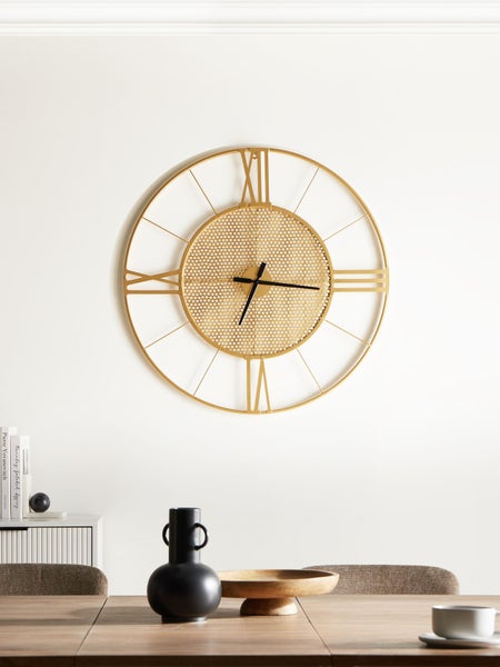 Dekorative Szene mit einer Wanduhr, einem Tisch mit Büchern und einer Vase mit Blumen neben einem Sessel