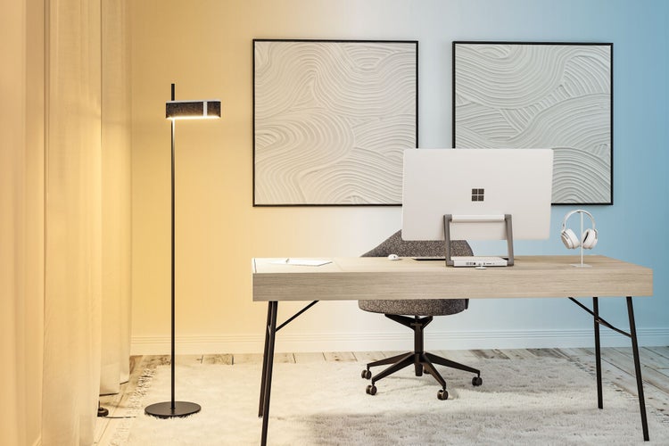 Helle Arbeitszimmereinrichtung mit Schreibtisch, Bürostuhl, Stehlampe und Computer