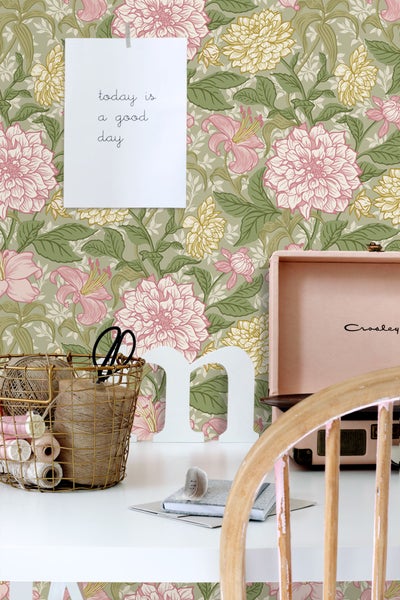 Dekoratives Zimmer mit floraler Tapete, Tisch und Accessoires für kreative Projekte.