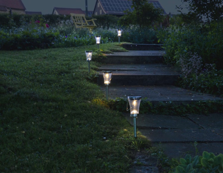 Szene mit Solarleuchten, die einen Gartenweg beleuchten.