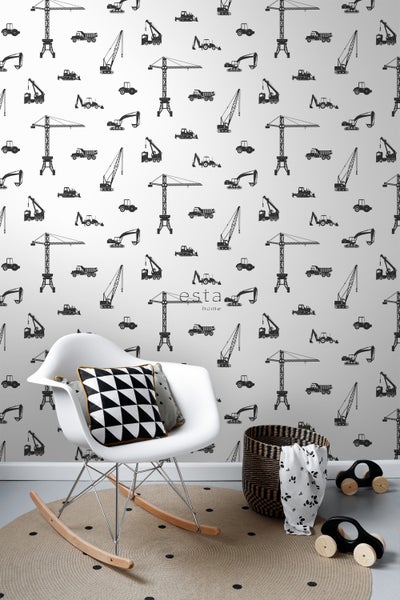 Szene mit einem Schaukelstuhl mit Kissen, einem runden Teppich, einem Korb und einer Tapete mit Baustellenmotiven.