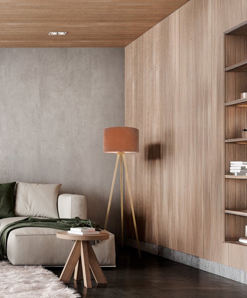 Wohnzimmer mit Sofa, Stehlampe und Bücherregal