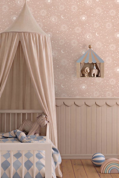 Kinderzimmer mit Tapete mit Sonnen- und Mondmuster, Kinderbett mit Baldachin und Wandpaneelen mit Wellenkante.