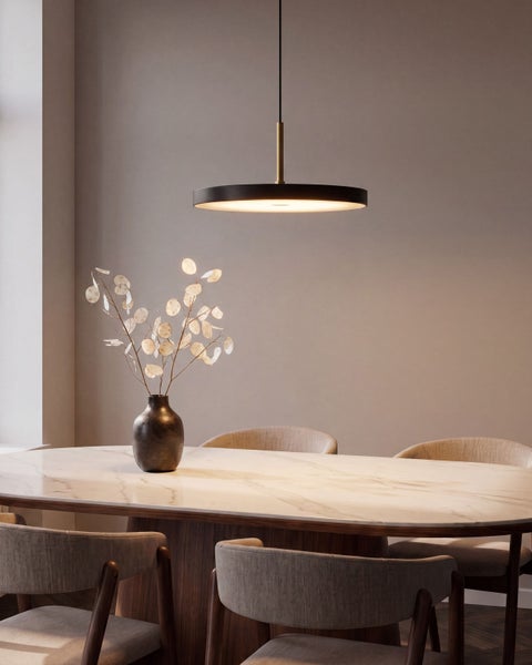 Moderne runde Pendelleuchte über einem Esstisch mit Marmorplatte und Polsterstühlen in einem eleganten Esszimmer.