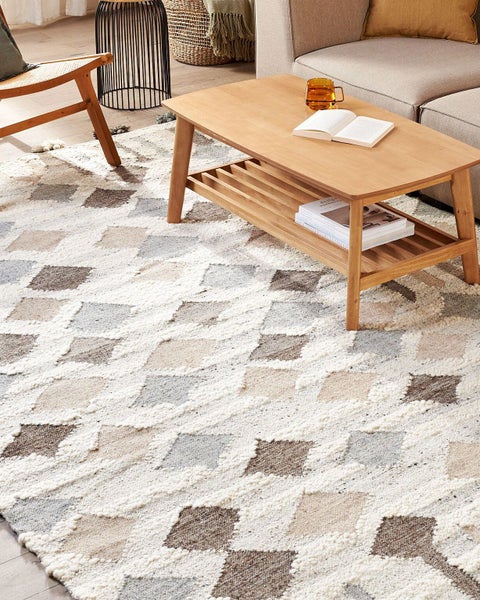 Szene mit einem Sofa, einem Couchtisch und einem Teppich mit geometrischem Muster