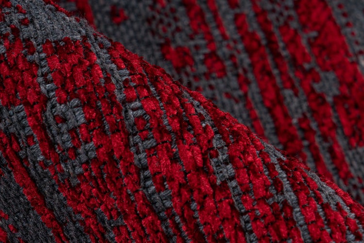Nahaufnahme eines gewebten Strukturstoffes in Rot und Anthrazit mit vertikalem Muster.