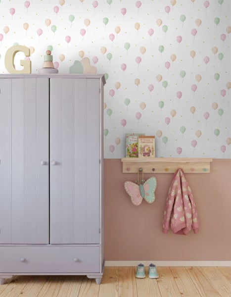 Kinderzimmer mit fliederfarbenem Holzschrank, Tapete mit Luftballonmuster, rosa Wandfarbe und einem Holzregal mit Kleiderhaken.