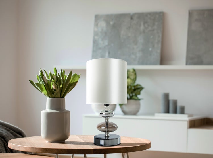 Dekorative Szene mit Tischleuchte und Blumenvase auf einem Holztisch