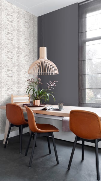 Esszimmer mit Holztisch, Stühlen, Pendelleuchte und gemusterter Tapete.