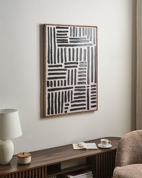 Abstraktes Wandbild mit schwarzen, strukturierten Linien in einem Holzrahmen über einem Sideboard in einem modern eingerichteten Raum.