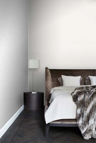 Schlafzimmer mit Bett, Nachttisch und Stehlampe für eine gemütliche Atmosphäre.