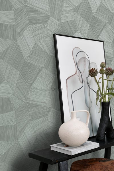 Nahaufnahme einer Wand mit geometrischer Tapete, dekoriert mit einem Bilderrahmen, Vasen und einem Buch