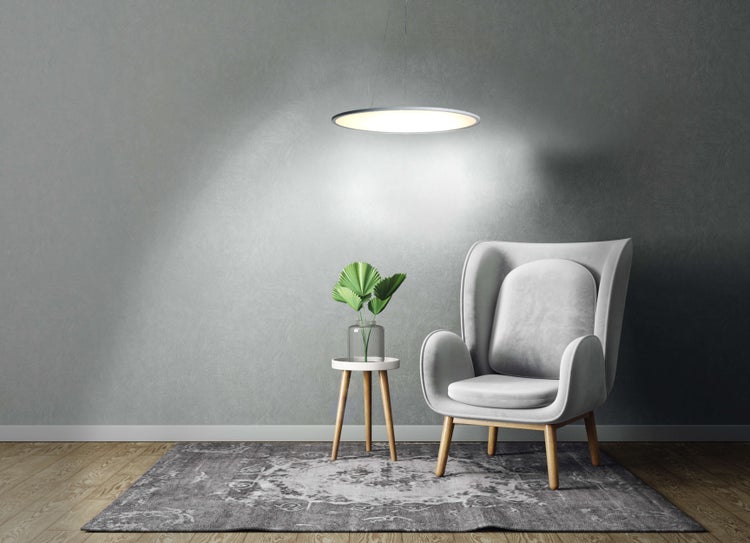 Sessel mit Tischlampe und Teppich auf Holzboden