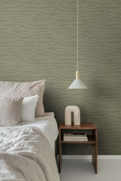 Schlafzimmer mit Vliestapete mit wellenförmigem Strukturmuster, kombiniert mit minimalistischen Möbeln und einer Hängeleuchte.