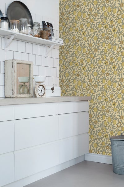 Küchenszene mit weißen Schränken und Tapete mit Fruchtmuster
