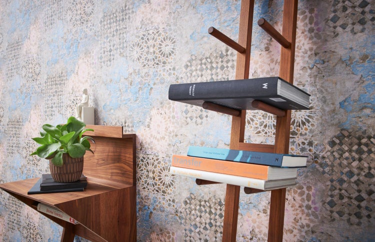 Dekorative Szene mit Ornamenttapete, Skulptur und Zimmerpflanze auf einem Holzregal