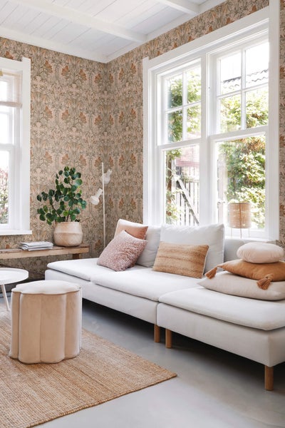 Wohnzimmer mit gemusterter Tapete, Sofa und Teppich