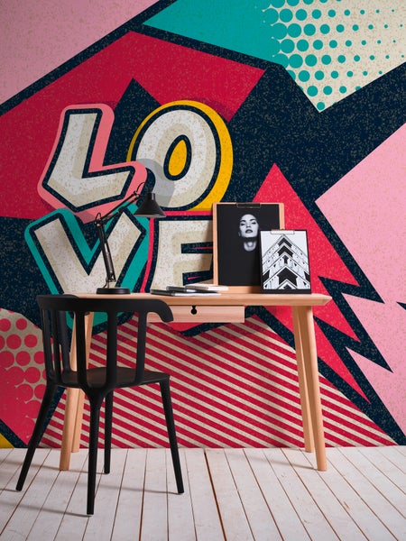 Fototapete im Pop-Art-Stil mit dem Schriftzug LOVE hinter einem Schreibtisch aus Holz mit einem schwarzen Stuhl und einer Schreibtischlampe.