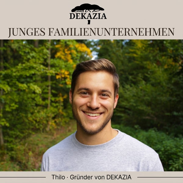 Thilo, Gründer von DEKAZIA, einem jungen Familienunternehmen, lächelnd in einem hellen Wald. DEKAZIA Logo.