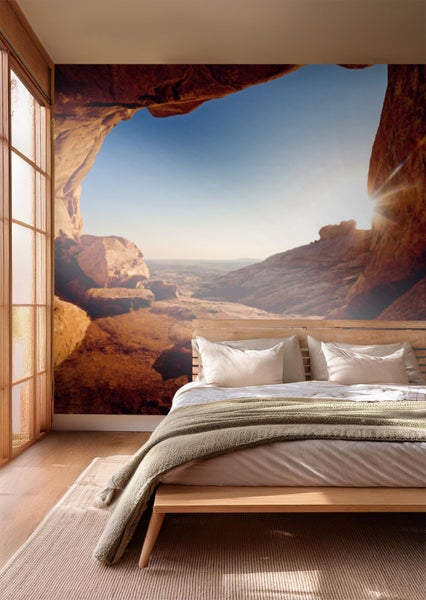 Helles Schlafzimmer mit Fototapete eines felsigen Hohlraums über dem Bett