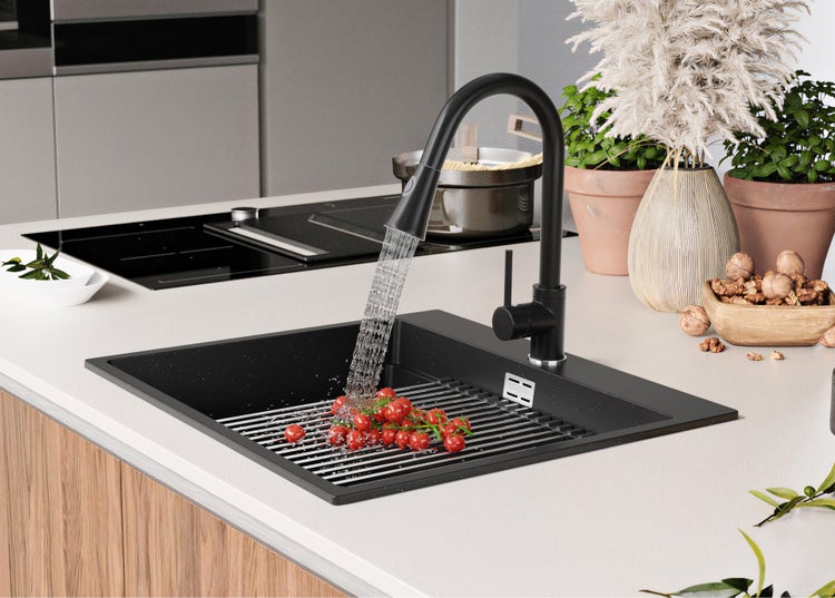 Schwarze Küchenspüle mit Armatur und Tomaten