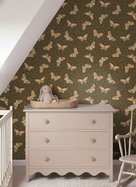 Kinderzimmer mit Kommode, Korb mit Stofftier und Tapete mit Schmetterlingsmuster