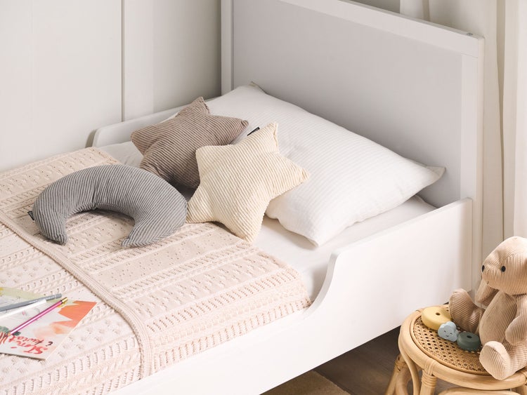 Kinderbett mit Stern- und Mondkissen sowie Strickdecke