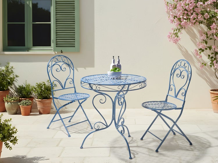 Gartenszene mit blauem Metalltisch und zwei Stühlen, dekoriert mit Pflanzen und Geschirr