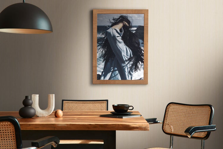 Esstisch mit Stühlen, Lampe und Tapete mit geometrischem Muster in einem hellen Raum.