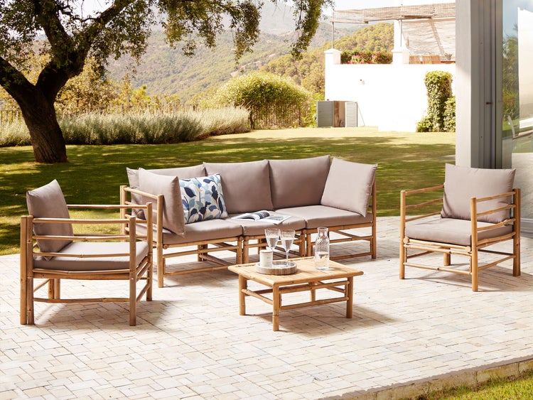 Gartenmöbel-Set aus Bambus mit Sofa, Sesseln und Tisch auf einer Terrasse
